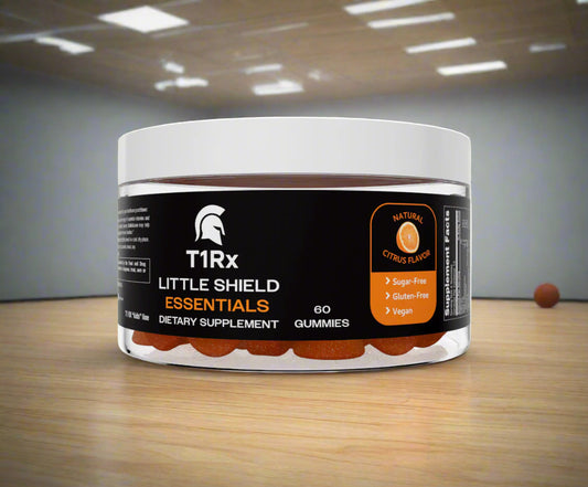 T1Rx Little Shield Essentials dietary supplement jar on a wooden surface with a blurred indoor background.